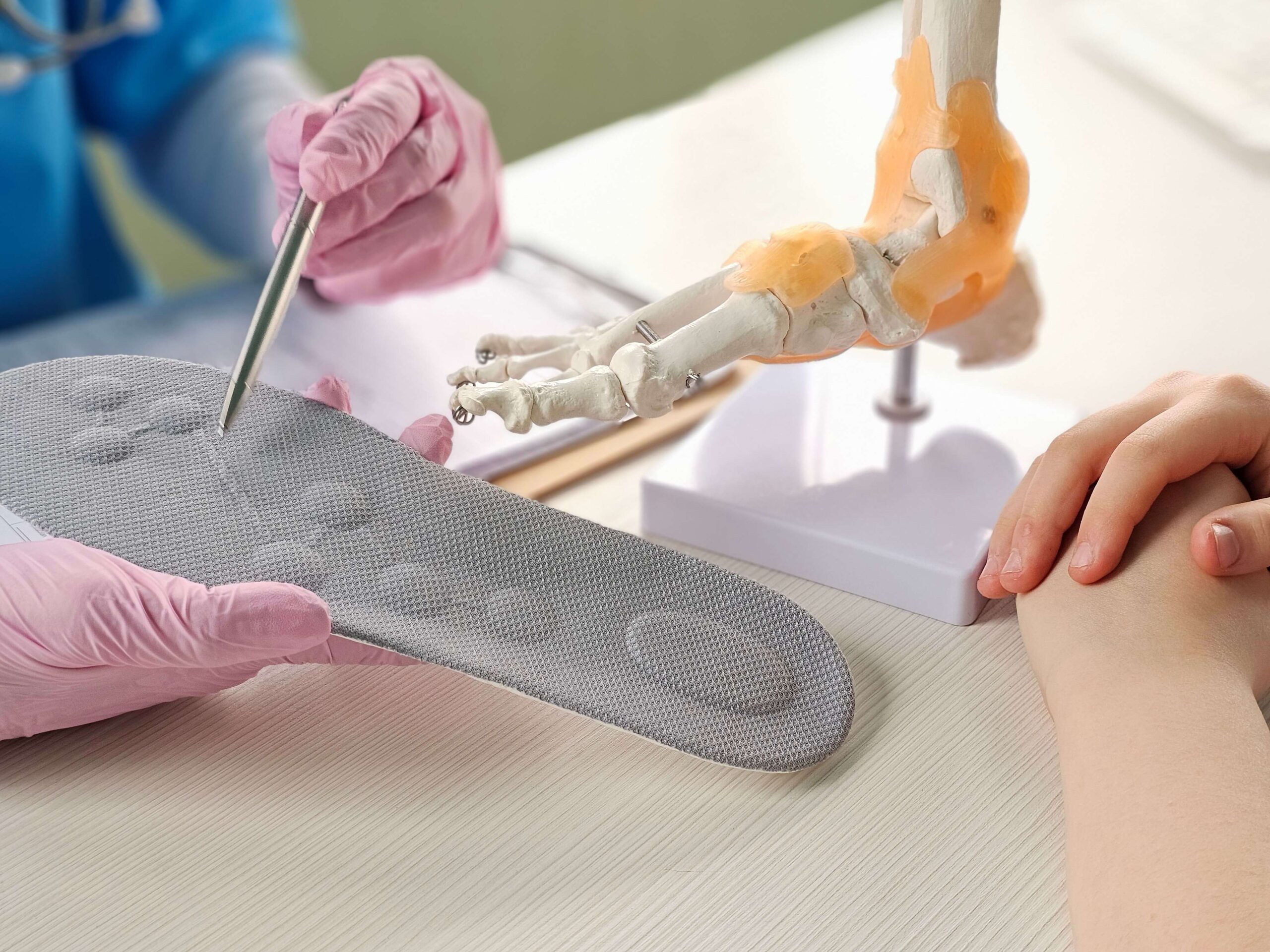 Doctor installing a custom orthopedic insole on a patient foot concept